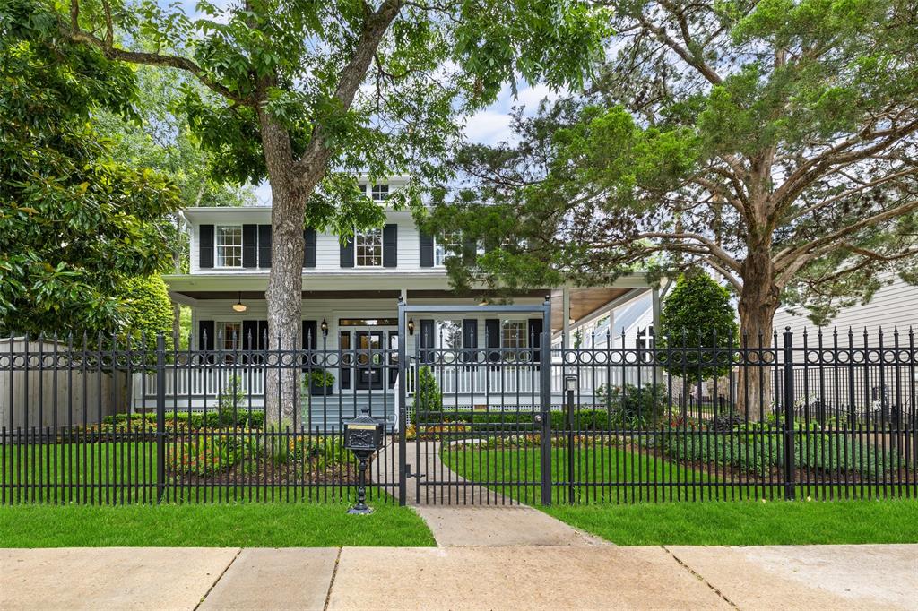 The front of the home is surrounded with a private gate with both a sidewalk entry gate and an electric driveway access gate.