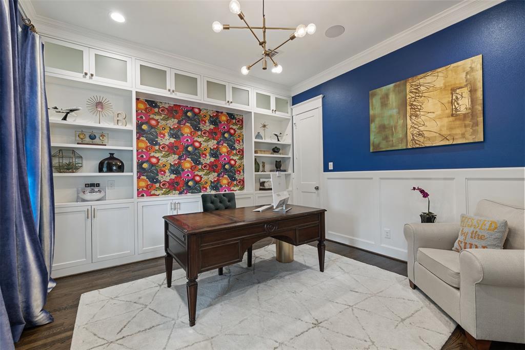 Located downstairs off the main entry, you will find this large study with custom built-in cabinetry, wainscoting, and Sonos enabled built-in speakers.