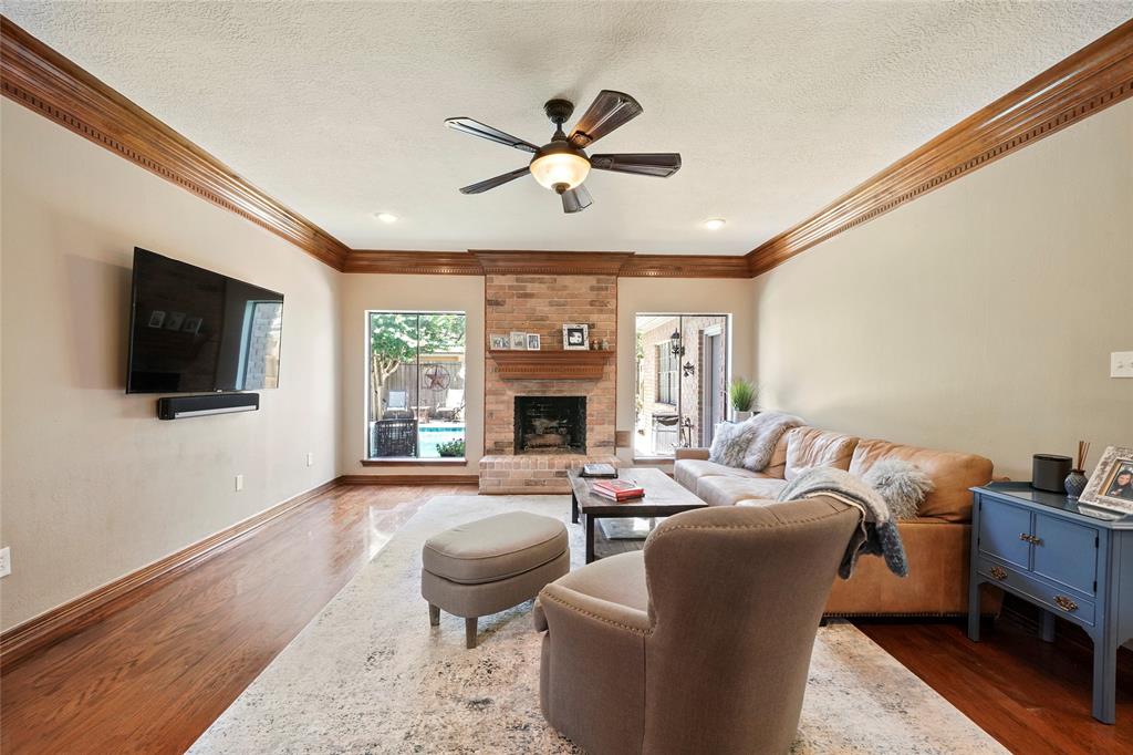 The living room features a gas log fireplace and looks out to the backyard oasis.
