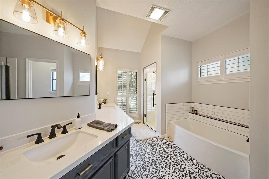 The primary bathroom was remodeled in 2019 featuring modern finishes, double sinks, ample storage space, built-in linen cabinet and an updated tub and shower.