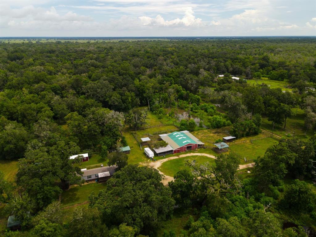 Aerial view of your new property.  Shade, pond, 3/2, 7.5 acres, 10 stall barn, with 10 separate turn-outs with run-ins. RV Hook up and privacy.
