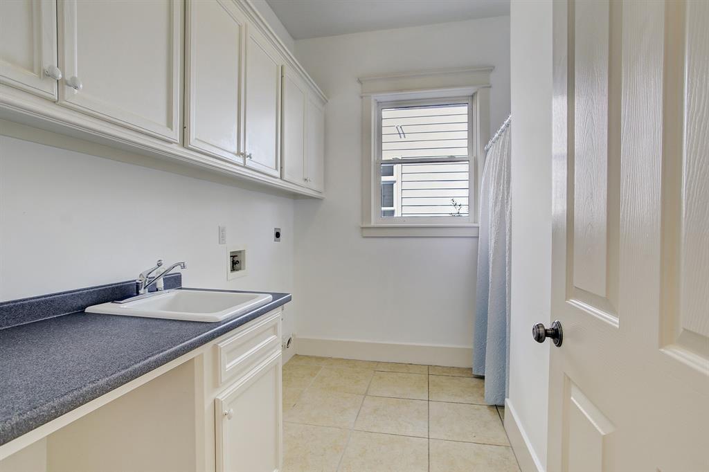 There is above average storage in this home, in virtually every room. The laundry is no exception with abundant cabinets and a sink. Behind the curtain to the right of the window is a central vacuum system.