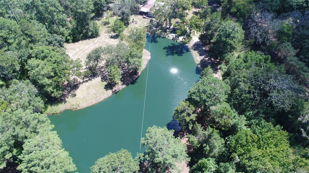 380 PR 6170 Grapeland, Texas This older three-bedroom, two-bathroom home has been completely remodeled with new electrical, plumbing, air/heat, and a new metal roof. All the new appliances and furnishings stay with the property. There is a water well, as well as community water on the property. Outside, you will enjoy sitting on the covered front porch and back porches. There is a covered RV shed with water and its own septic system, an insulated outbuilding, a detached garage, and a covered barbecue area with a smoker and firepit. The pond has been stocked with bass, crappie, perch, and catfish. There is an automatic fish feeder and commercial grade aerator in the pond. The property is fenced and has roads around the property. There is a timber on the property and there is a timber exemption currently in place. The owner reports good deer hunting as protein is fed year-round. All deer stands on the property will convey with the sale. Call today!