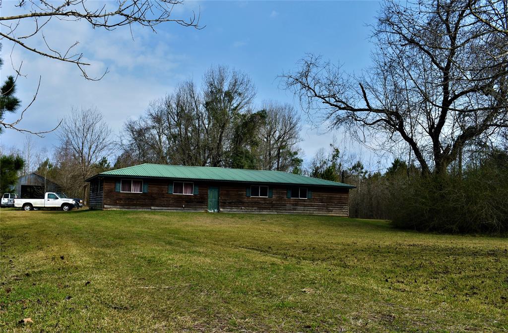 418 County Road 2003 Liberty, Texas If you are looking for country living, this is it... a log cabin feel with a tin roof, on a quiet country road is waiting for you! This two bedroom, three bathroom home, built in 2008 is situated on 9.98 acres in Hardin. The homes living area has an open concept, while the bedrooms feature their own private bathroom. The primary bathroom has a jacuzzi tub and separate shower. Both bedrooms are large and have walk in closets. The attached two car garage features an office space or bonus room with a full bathroom. Outside, the property is partially cleared with plenty of room for a pool if desired. The home is located about 40 minutes from Beaumont and 45 minutes from Houston. A new 4-ton Ruud Sure A/C unit with a heat pump will be professionally installed prior to closing. The home did not flood during Harvey or Imelda.
