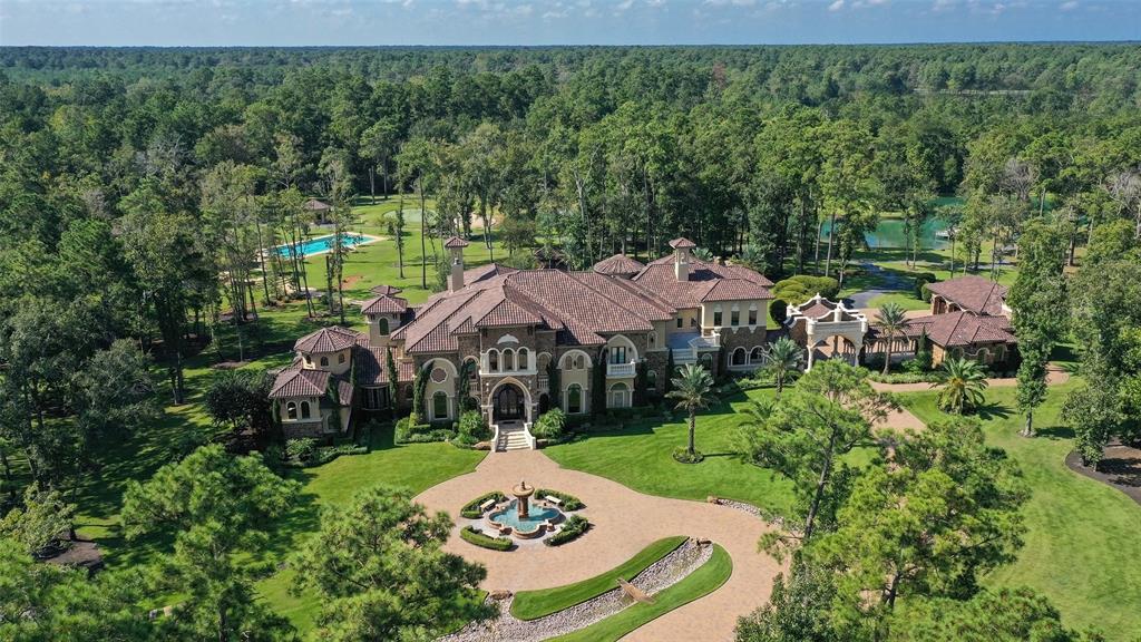 Spectacularly landscaped grounds surround this sprawling home in scenic Magnolia. Step through the arched double-door entry & into the grand 2-story foyer, w/twin wrought-iron staircases & custom chandeliers.This attention to detail carries through all 14,377 sf of the estate, from the gourmet kitchen with separate catering kitchen to the formal dining room.Treat guests to a wine tasting in the climate-controlled wine room before leading them to one of the 3 pools, including the tiered main pool with swim-up bar tucked into a cave. Indoor recreation can be found with the 2-story library & games room plus pub. Every inch of the 20+ac resort-like grounds is ready to enjoy thanks to landscaped lighting & golf cart paths. Practice your swing at the par 3 golf hole by the 2.5ac pond stocked w/bass for private fishing. This immaculate turnkey opportunity waits to welcome you home.