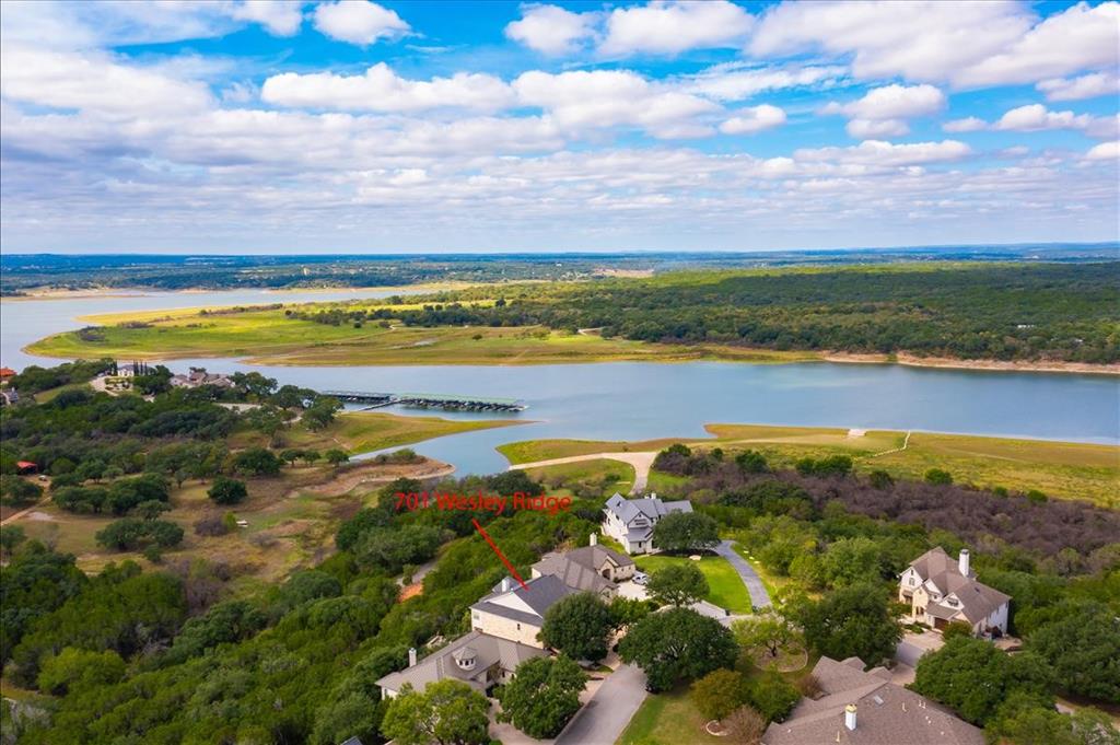 Gorgeous one of a kind, CUSTOM BUILT home BREATHTAKING LAKE TRAVIS VIEWS.  RECENT UPDATES include STAINLESS STEEL APPLIANCES & NEW CARPET in secondary bedrooms.  This home has EXTENSIVE LANDSCAPING that creates a wonderful outdoor experience.   Views of Lake Travis from both back patios, as well as the hot tub!  Kitchen opens the living area, with vaulted ceilings and stunning wood beams.  Beautiful stone masonry surrounds the fireplace, dining room arches and counter top seating area.  Primary bedroom has hardwood flooring & lake views.  Man cave/den on the main floor with iron doors and hidden study.  Lower level has a living area that exits to the lower level patio and hot tub.  Large storage area under the staircase and bonus room to use as another storage area or man cave. Ridge Harbor is a gated community complete with a marina, two boat launches, community pool, tennis court.  SCHEDULE YOUR PRIVATE TOUR TODAY!  KINDLY LEAVE FEEDBACK FOR THE SELLERS.  TAKE A LOOK AT THE VIDEO!!