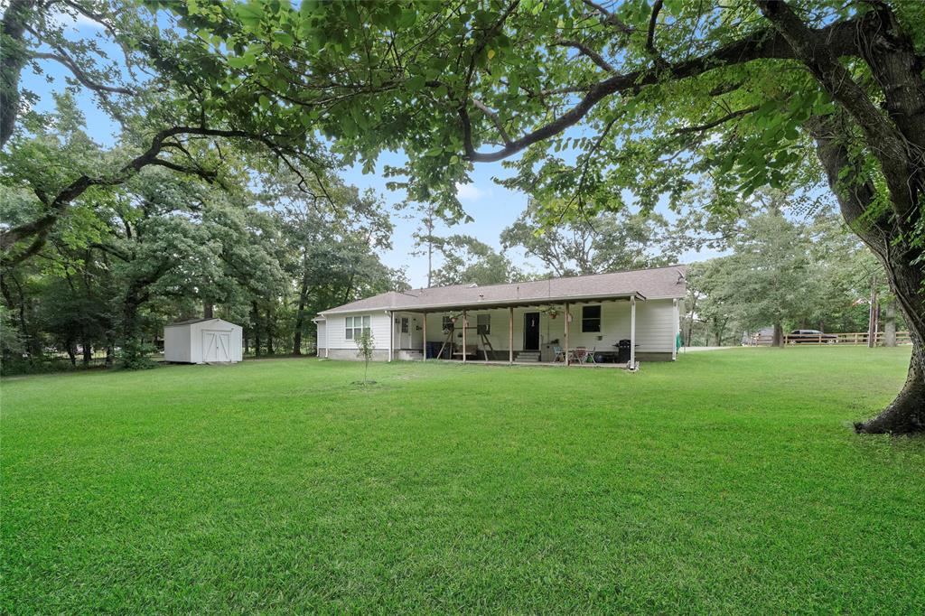 Out back, you will find a large covered patio and a storage shed. The covered patio overlooks the large wooded lot.