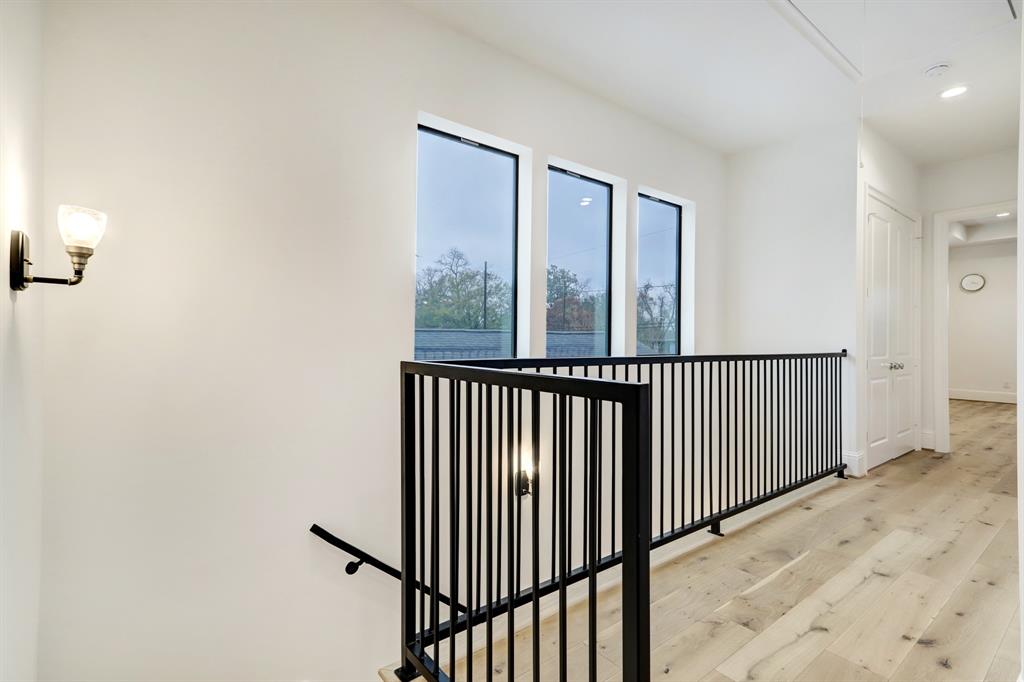 Hallway that leads to primary bedroom with a gorgeous wrought iron balcony.
