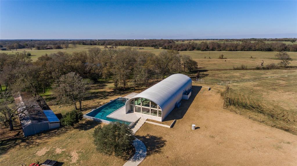 5136 Silver Hill Road Bryan, Texas • Main residence constructed in 2017
• Excellent investment opportunity, property is easily divisible
• More than 1,100’ of frontage on Silver Hill Road
• Wraparound swimming pool
• Tile covered patio / outdoor entertainment area
• 3 bedroom / 3 bathroom guest house
• 4,000 SF barn with separate feed room, tool room, equipment, and wash room
• Multiple outbuildings for storage, feed, livestock
• Foreman’s quarters
• Ranch features include brick entrance, asphalt and concrete driveway, four fenced and cross-fenced pastures, pipe fencing, windmill, two water wells, propane tank, and pond
• Furniture, fixtures, and equipment negotiable
• Schedule appointment 24 hours in advance