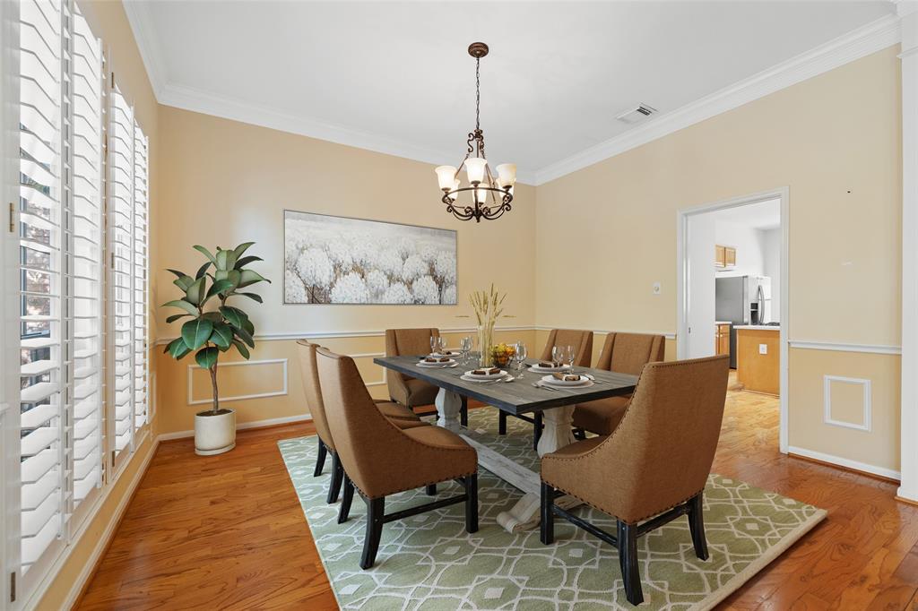 The dining space is large enough for a six or eight person dining table and features wood floors and plantation shutters. This photo has been virtually staged.