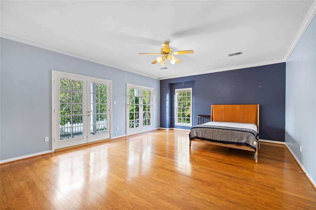 Spacious primary bedroom with doors leading to the private balcony overlooking the bayou.