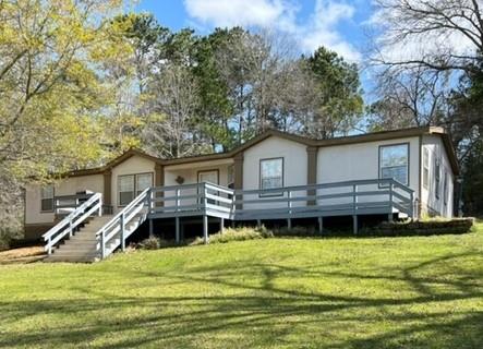 11 Acres near Lake Livingston! Manufactured Home (2112 sq/ft per CAD) and a 1955 wood frame home (1220 sq/ft per CAD and uninhabitable).  The 3 bedroom, 2 bath double wide manufactured home is move in ready.  The primary bedroom has a study/sitting area off the main bedroom area, and an en suite bathroom with 2 vanity areas, walk-in shower, soaking tub, and a large walk-in closet. Open concept living & dining.  The kitchen has opening to the living area as well.  The large kitchen area has ample cabinet space. There are 2 additional bedrooms, 2nd bathroom (tub/shower combo), and a utility room.  There is an oversized garage/storage/shop on the property.  Partially cleared property. The land leads down towards a creek at the back of the property.  Minutes from Coldspring, and very near the Sam Houston National Forest, and Double Lake Recreation Area.