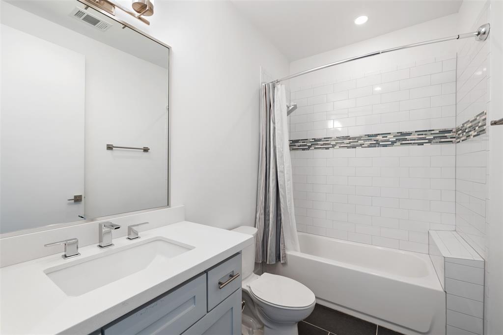 This secondary bathroom offers a tub/shower combo, quartz countertops, and nice storage.
