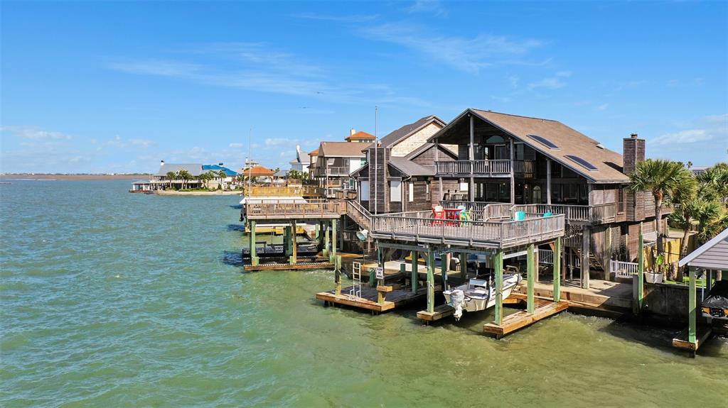 Location, Location, Location! This bayfront home has panoramic views of the bay, & immediate open water access. Not only is the location fantastic, but the home offers many perks as well. The home features luxury laminate flooring, hurricane shutters, a stone surround wood-burning fireplace, a double boat slip, & wet bar. The first floor has a spacious open floor plan, 2 bedrooms, 1 bath & a full-size utility room. The 2nd floor features the large primary retreat with jetted tub & separate shower in the bathroom. Abundance of closet & storage space allow it to be a great primary home, 2nd home, or investment property.  Enjoy the great view from covered double decks, spacious deck over the boat house, or by the bar under the home. The Sunsets are stunning! Don't let this bayfront opportunity pass you by!  The home does convey furnished with exclusions.  Do not rely on the photos for the furniture that will remain.