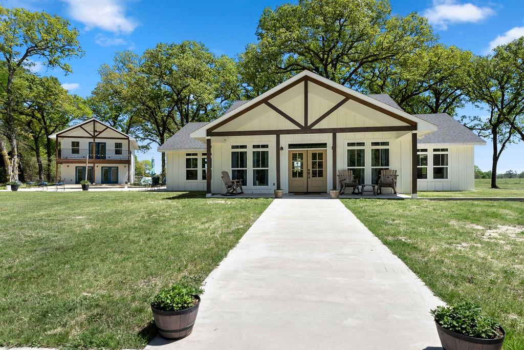 This custom built, one of a kind farmhouse style home situated on 5 acres features 2 bedrooms and 2.5 baths. Additionally, there is a 2 bed, 1.5 bath 1,536 Sq. Ft guest home and an in-ground pool! Upon entering the main residence, you are greeted by the soaring high vaulted ceilings and real hardwood flooring throughout the home! The large kitchen features a gorgeous brick accent wall + built in shelving and white cabinetry + ample countertop space, SS appliances, + a mix of granite & quartz countertops and a walk-in pantry! Both bedrooms are generously sized and boast en-suite baths + access to the outdoors. The 2-story guest home flaunts wood flooring, beautiful backsplash in the kitchen + SS appliances and an oversized upstairs bedroom leading to the covered balcony overlooking the pool. Exterior features include a large pool, covered front porch areas + a massive back porch on the main home, and 5 acres of unrestricted, mostly cleared land! Schedule a private tour today!