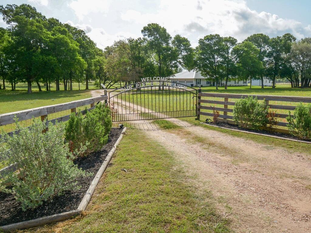 As you enter, the gate reads..OUR PIECE OF HEAVEN and that's what this could be for you! Situated in the bucolic countryside of beautiful southern Fayette County just inside Lavaca County is a country estate located on 7 plus acres with a pond. The home is surrounded and lined by mature hardwood trees, is 2256 sq ft with 4 beds, 3 baths, open air den/kitchen that leads onto the patio and pool.  It was designed with good use of space and is wheelchair accessible in most areas of the home. Recent updates include a new metal roof, french doors, new fireplace, new floors and granite countertops. There's also a 50 amp RV hookup in the driveway. The property is completely fenced with a storage shed and separate RV storage barn. There is a 2 bay garage with a 3rd bay that can be used for an additional car or shop equipment.  Call the listing agent, Max Coppinger for more information, but do it quickly... this one will not last long!  CHECK OUT THE PROPERTY INFO ATTACHMENT!