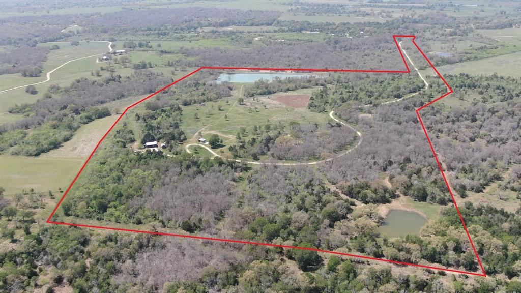 Located just 30 minutes from Austin, this recreational showplace is waiting for its new owner to take it to the next level. At the end of a private drive, the current owners have meticulously put together the ideal gathering spot. Looking out over the western pasture is a well-appointed outdoor kitchen with a 5,000sq foot lighted, irrigated lawn. Enjoy an evening with friends while sitting around the stand alone fireplace offset from the cooking area. This hilltop would make a perfect homesite looking out over the stunning 3 acre lake that has been stocked with bass, bluegill and catfish. In addition to the lake, there are 2 other ponds that attract wildlife to this recreational mecca. The property is serviced by a 660’ well pumping 50 GPM that is plumbed to the kitchen, irrigated lawn and also a high fenced garden for all of your home grown vegetables. In addition, there is a 20 x 30 steel barn. AQUA water at the road. Bluebonnet in place. Light restrictions to be enforced by seller.