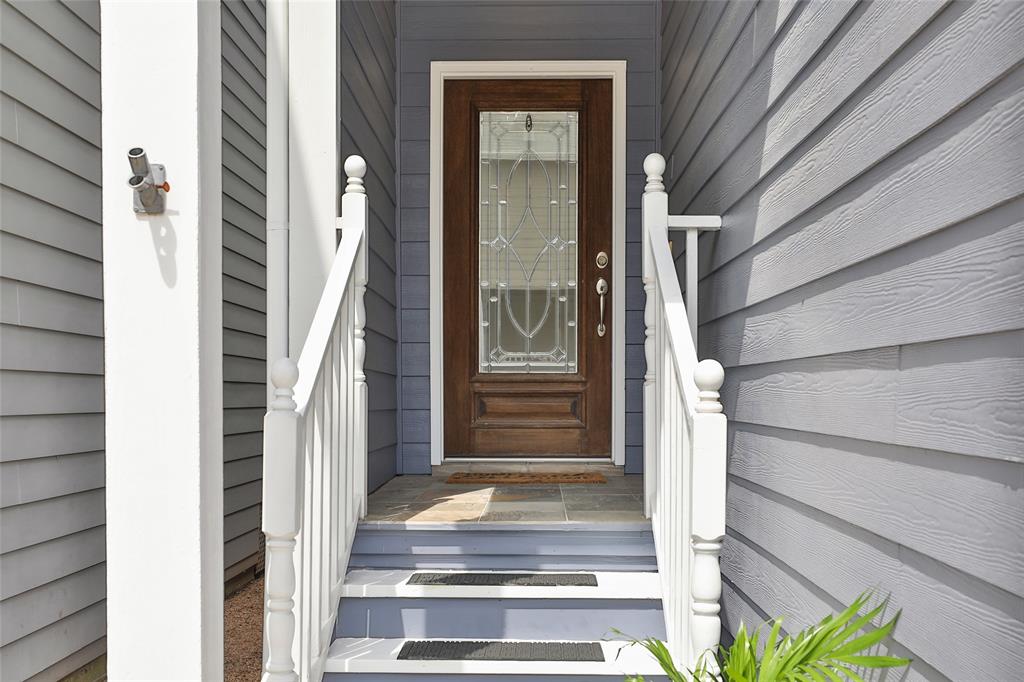 The front door of the home is quite inviting with a solid wood and glass front door.