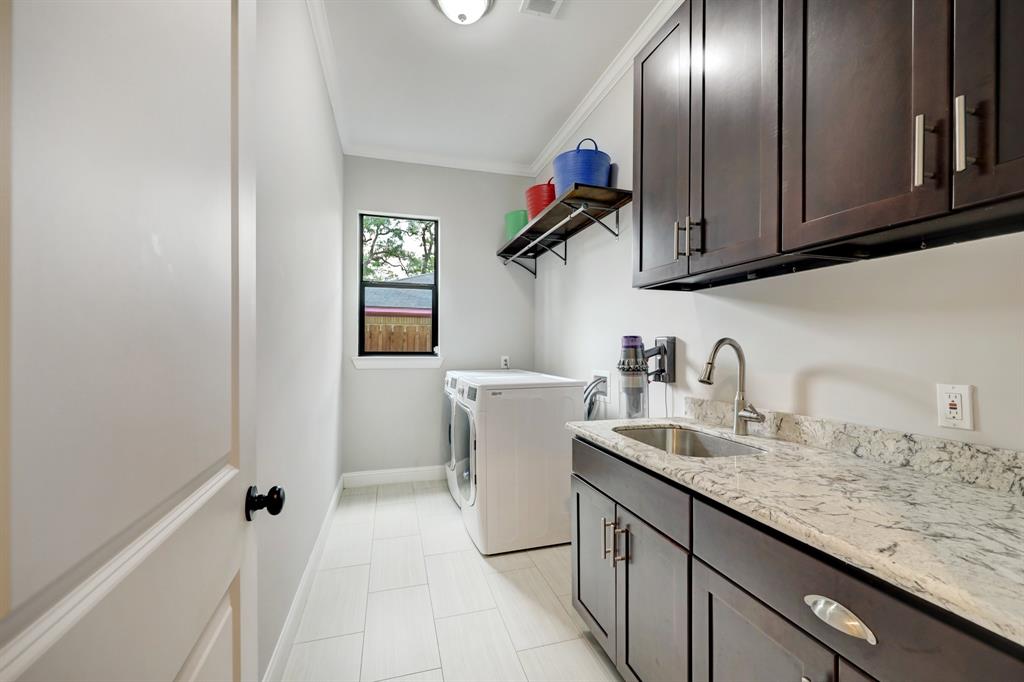 The laundry room is quite big with natural light, a sink and ample cabinets, as well as clothes hanging and folding space.