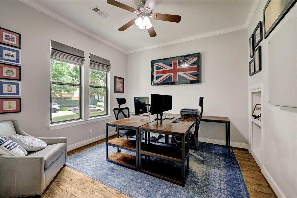 Off the entry hall and overlooking the front yard and Richelieu Lane is a home office, spacious enough for two desks and comfortable seating.  At the back right corner of the photo is a hidden door leading to under stair storage.