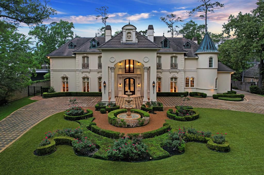 Stately and ideally positioned on a 1+ acre lot, this extensive custom build by King Residential is an exquisite traditional French masterpiece in Hunter’s Creek Village. This Memorial estate showcases cohesive French design elements blending rustic textures and bold materials. The elegant grand entry showcases 2 chandeliers, marble flooring and custom pillars. 5-6 bedrooms, including a stunning main floor primary suite with a spa bath and his and hers closet, theater room, office/study and a spacious flex room. The hand-painted ceiling along with the striking detailed cabinetry around the gourmet island kitchen allow for warmth throughout the house. Rich textures like marbled floors, brass, and soft white walls accent the home. The exterior grounds are equally captivating, featuring lush landscape, summer kitchen and a picturesque resort style pool. Offering its owners the utmost privacy along with excellent space for entertaining for both intimate gatherings or grand scale events.