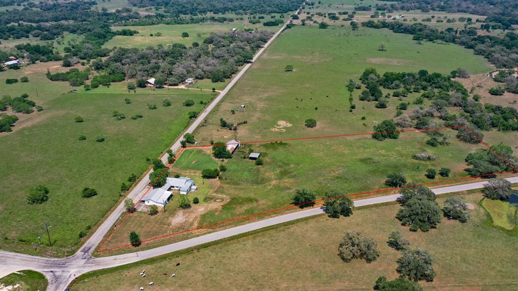 BEAUTIFUL quaint COUNTRY living on 5.63 acres located in Hallettsville, TX on a corner lot! The main home features 3 bedrooms and 1 bathroom. Wood walls inside the home are historic from the 1930's. Separate guest quarters.  This is a prime location directly across from Ezzell School Pre-K through 12th grades. Multi-purpose land use: gas station, store, cattle, horses. The possibilities are endless with this property. A historical land marker is located on the property. Close to an off-road mud park. Ezzell ISD!