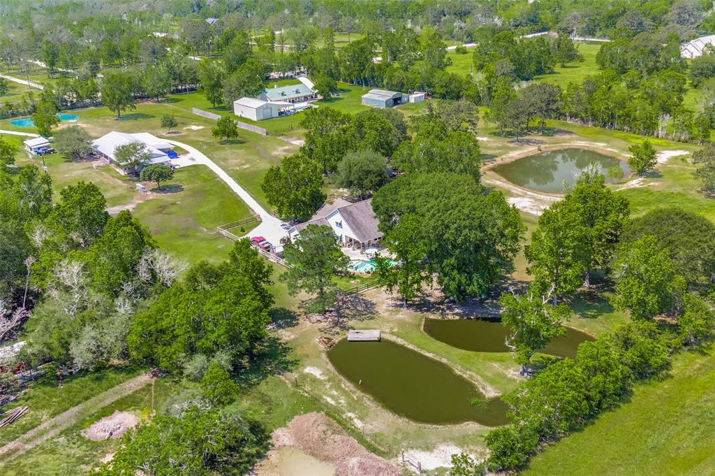 Country Living in Paradise!!! This rare find is located in Crosby just 25 minutes from Downtown Houston. Close to Beltway 8 and I-90! Property IS 5 ACRES and unrestricted (listing says 4 because there is two tax records. 1 acre is with the house only and other 4 includes the rest of the land).This beautiful piece of land has horse stables, a separate guest house with kitchen, tack room, huge three bay workshop, three stocked ponds, paradise pool, storage container, and much more. Main house offers four bedrooms, two baths and soaring ceilings. Property is gated with roads that lead to the house and barn. Pastures are all gated off in a "U" like shape for horses to roam property without going down main drive. Custom Home built in 2011. Don't miss your opportunity enjoy the country life!