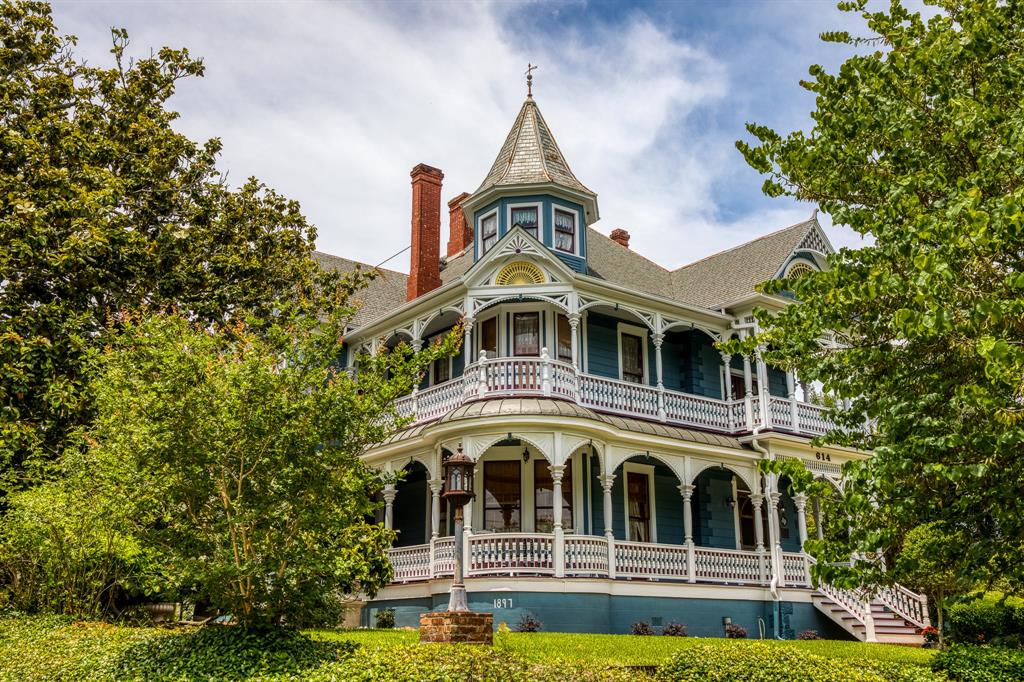 The Wood–Hughes House is a historical treasure on the TX Historic Commission & the Nat'l Register of Historic Places. Built in 1897 the house is a beautiful example of Late Victorian architecture. It boasts 3 stories w/the 3rd story being a floored attic. the home features 2 lg parlors, formal dr, butler’s pantry, 2 lg foyers, 4 bdrms, 4 bthrms, & 4 porches. The home retains its original 12-ft ceilings downstairs w/the original painted tin, 11-ft ceilings upstairs, long leaf heart-of-pine floors, original transoms, pocket doors, a courting porch & stunning stained-glass windows. The current décor maintains the character & charm of the late 1800’s. The lawns are beautifully manicured and adorned by a charming gazebo. The rose garden is timeless & the 4-season Victorian gardens always have something blooming.  The 5-car garage w/attached carport is used as a wood shop. This outstanding estate sits on a .7acre corner lot & is in walking distance to Brenham’s historic downtown district.