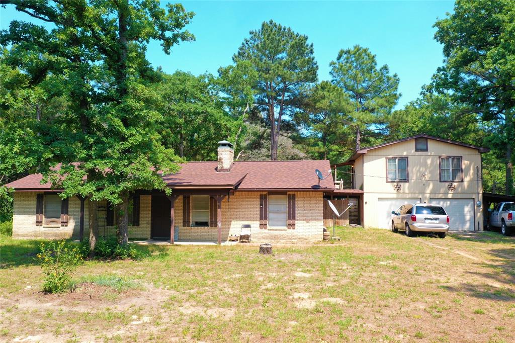 Comfortable Country Living just minutes from I-45! House & Garage Apartment on Approx 5 Acres! Great way to have addl living space for extended family members or for rental income. 3 bed, 2 bath, approx. 1200 sq. ft. main house, BOTH BATHS & KITCHEN REMODELED! New Roof 2021, Beautiful kitchen cabinets with granite counter tops, tile backsplash, electric range, microwave above, dishwasher, & wood look tile flring, WBFP in the living room & hearth in the master bedroom to add future wood burning stove if desired, master bath has low profile shower, bowl sink on granite counter,  2nd bath with gorgeous custom tile shower & flooring, new vanity, split bedrms with carpet, separate laundry rm, big double garage with apartment above approx. 672 sq. ft. 1 bed, 1 bath with tub & shower, living rm & kitchen, new mini split unit, 220 for RV hookup or welder, loaded with mature trees & lots of room to explore! fenced on three sides, metal barn with tack room & antique barn, outside the city limits