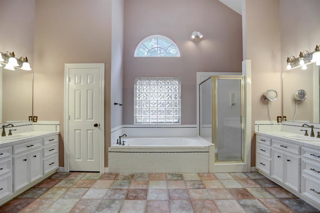 Huge primary bathroom is your oasis. Note the soaking tub, high ceilings, separate shower and dual vanity areas. Make this yours with some custom design touches.