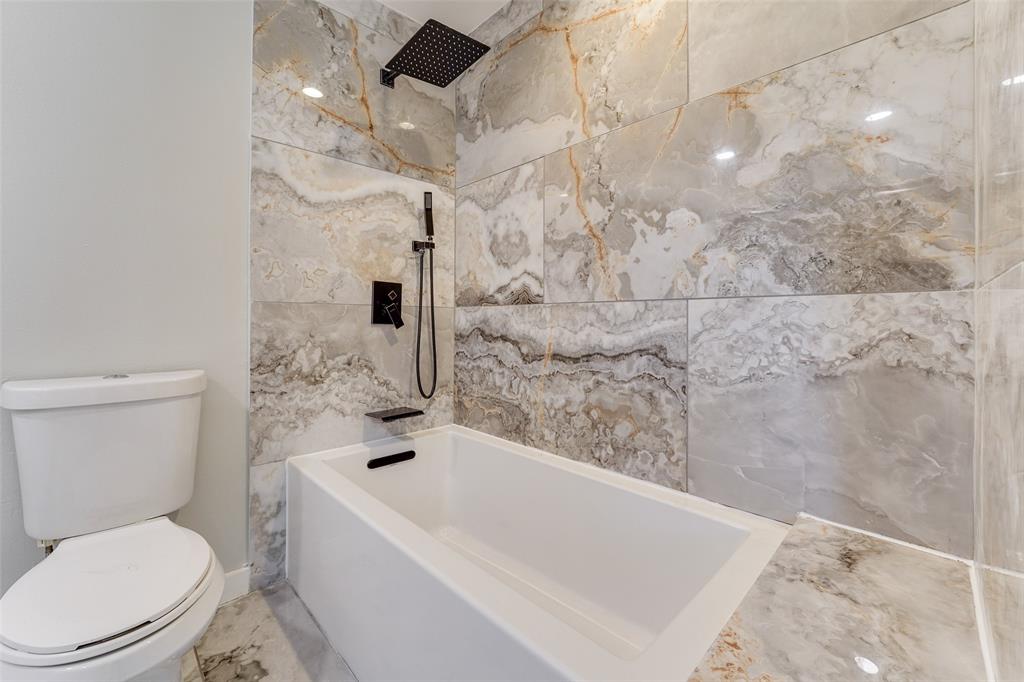 Luxurious primary bath with soaking tub, dual sinks and porcelain tile.