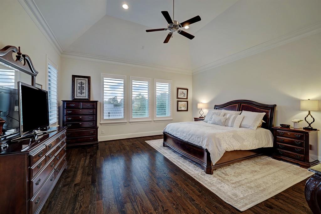 Handsome, spacious primary bedroom with plantation shutters and tray ceiling.
