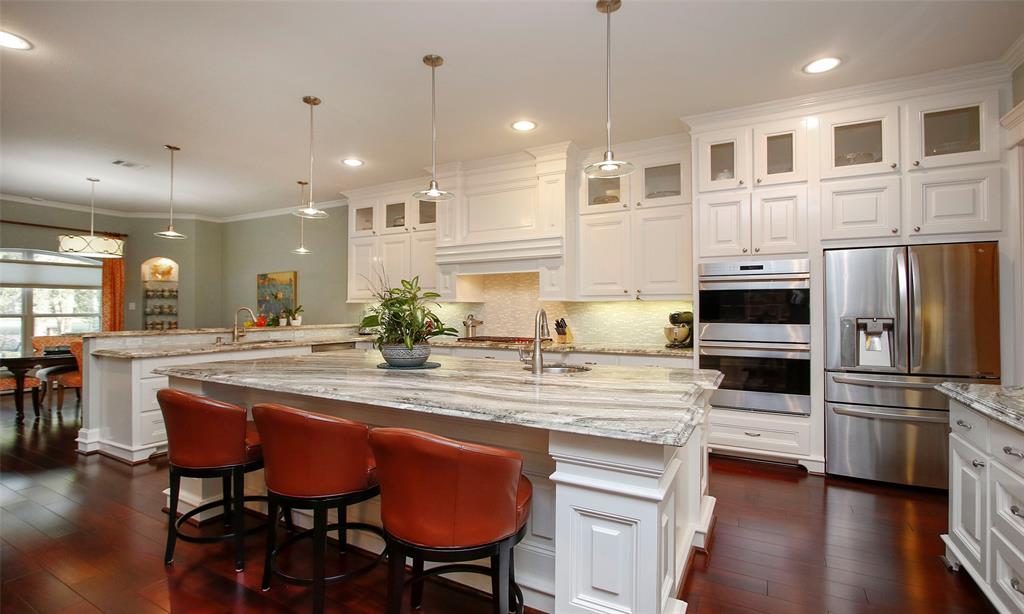 Gorgeous island kitchen that is very functional for the cooks. Stunning granite counters, custom cabinets with glass front tops to display your dishes and again notice the detailed molding around the island! Darling pendant lighting insures shining to this fabulous kitchen!