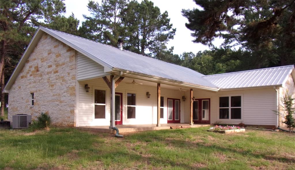 Don’t miss this Texas Gem. Custom 3/2 open-concept home enveloped in native Austin stone with metal roof on 56+ acres. Hickory & tile floors throughout, granite counters, WBFP & tiled and covered porch. High ceilings, full wheelchair accessibility. Attached carport & additional outbuildings. The gently rolling blend of improved pasture is balanced well with native hardwoods & mature pine, fenced & cross fenced. Live creek & natural springs feed a small lake. Property is home to 7 Longhorn cattle which can be adopted. Set up for horses with a 6-stall horse barn & large tack room/shop with AC, plumbing, insulation & electric. Covered barn storage. Second home is a 3/2 doublewide mobile home with attached large garage & a back deck overlooking the lake.