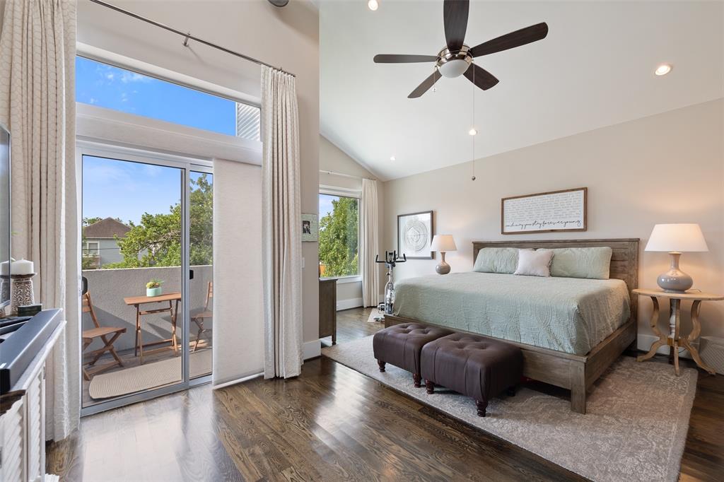 The primary bedroom offers an extra seating area, hardwood floors, and an outdoor balcony. Like the main living area, the outlets are also tucked way in the baseboards. You'll also find gorgeous curtains and window treatments throughout the home.