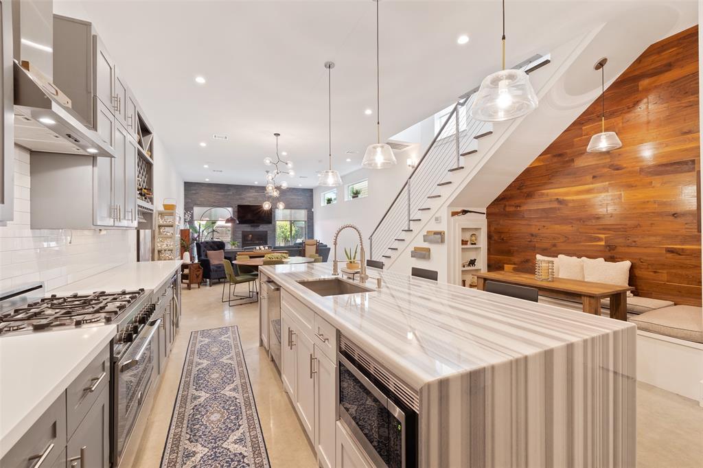 The center-island kitchen offers tons of counterspace for cooking prep and lots of storage in the stylish custom cabinetry. You're going to love the custom touches like the marble waterfall center island, the custom wine storage, and the elegant pendant lighting.