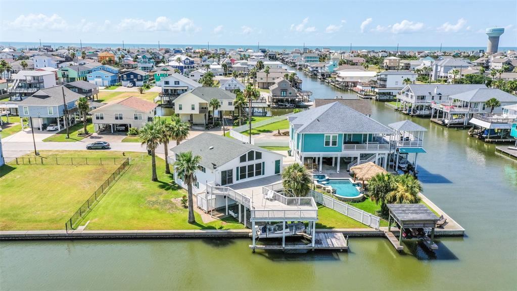 Absolutely STUNNING canal front home located in a cul-de-sac affording 117ft of water frontage. Plenty of room for that pool that you have been wanting. This meticulously maintained home boasts wide open entertaining spaces from wall to wall. Great split floor plan with souring ceilings in living area. Enjoy a famous Galveston sunset while relaxing on the oversized deck. Ground level entertaining mecca offers multiple gathering spaces both inside and out. Inside area features a bedroom, bathroom, kitchenette, and living area that’s not included in the sq footage. Walking outside you will find a boat house with lift, fishing pier, and plenty of yard space. Amazing opportunity to own a like-new canal house on an amazing lot.