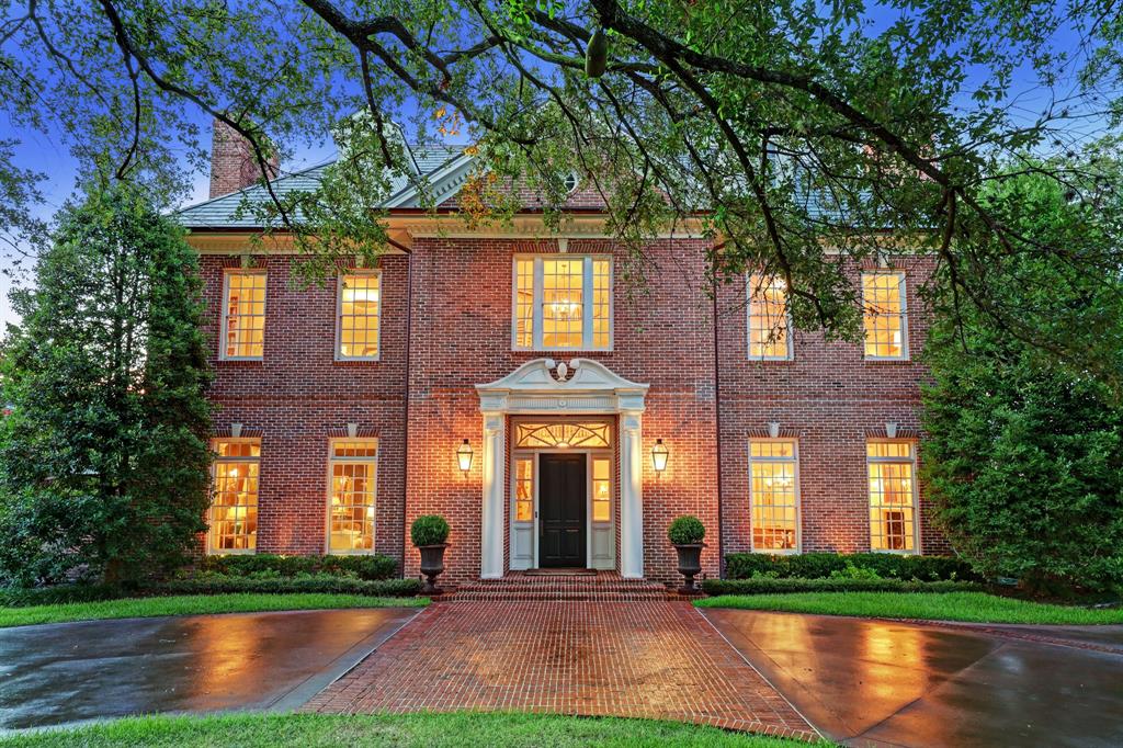 Situated in a prime location in River Oaks, this Georgian Colonial home blends symmetrical architectural elements with nuances of a more modern era floor plan and lifestyle. Inviting entry area with fanlight transom and a swans neck pediment over the front door. The home is richly appointed with stenciled hardwood floors in the foyer, elegant moldings throughout, a graceful descending staircase, and 12' ceilings in the main living areas on the first floor. A walk-in wet bar is between the living room and back library room. The library room offers access to a climate-controlled wine room. The sun room has pairs of French doors that open to the backyard patio and pool area. The kitchen and family room were remodeled by Dillon Kyle for a more open living area concept. Four or five bedrooms plus a two-bedroom apartment or quarters upstairs. Third floor game room and media room. Elevator goes to all three floors. Backyard with green space, slate patio, pool, and outdoor dining areas.