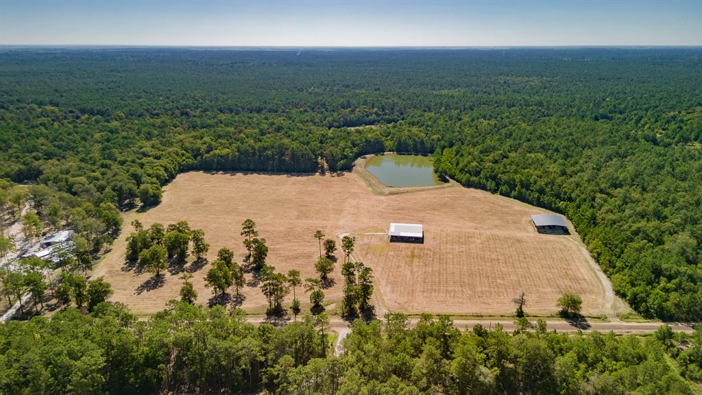 Located less than an hour from Houston, you'll discover a  beautiful 58+/- acre mini ranch in the heart of Chambers County. This working hay farm has 20 acres improved grass (Jiggs Bermuda) an Ag barn, a workshop, & is Ag exempted, an abundance of hardwood trees (Oak, Hickory, Pine, Sweet gum, Old Stand Cypress).  Gorgeous 3 +/- ac pond has a 12’ berm, auto fish feeder, (Florida large mouth  bass, Copper nose bluegill) an aerator, water level maintained by the 4" water well which has a submersible pump. There's a plethora of wildlife, deer stands, large food plot & deer feeder. Approx 1800’ of Turtle Bayou frontage, great walking & riding trails abound. Partially fenced/gated along the new county road. Possibilities are endless for this fabulous property, come build several homes (family compound), have a cattle/horse ranch, or a hunting camp. +/- 11 mi to schools, +/-48 mi to Hobby Airport,+/- 52 mi to IAH, 14+/- mi to shopping, +/-50 mi to Houston Med Center, +/- 50 mi to Beaumont.