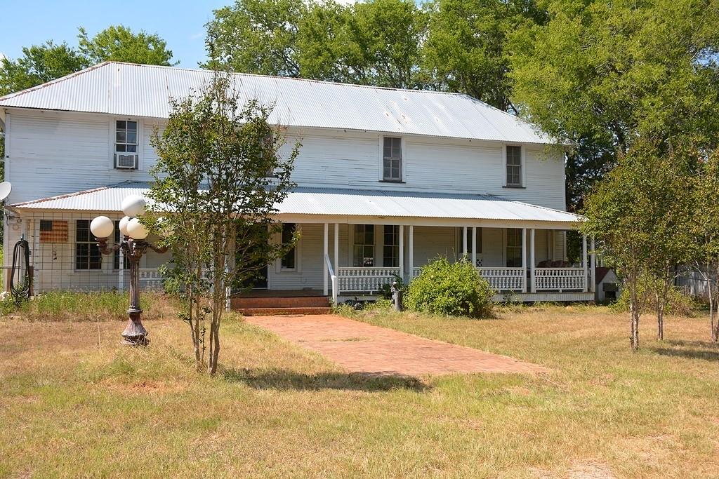This charming vintage farmhouse is a 'diamond in the rough' and is waiting for someone to bring it back to life. Tucked in the trees on hard-to-find small acreage on a rolling country road, the house has spacious rooms, high ceilings, lots of bead board and/or wood walls, pine floors, large windows, covered porch and numerous outbuildings. There's also 2 fireplaces (1 wbfp down, 1 propane fp up) and ‘vintage style’ propane stove/heater (looks like a wood stove) down.

Downstairs: Living room/study/kitchen/bedroom/bathroom; upstairs: 2 bedrooms/bathroom and gameroom.

Please note: the property is in an estate and to be sold 'AS IS, WHERE IS'.  Buyer will need to obtain new survey.

Gate is locked. Please call for appointment. Thank you.
