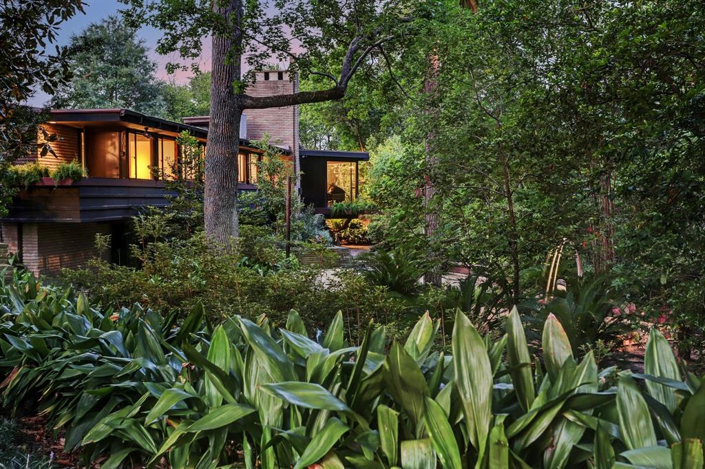 Exceptionally sophisticated historic Mid-Century Modern home built by architect Karl Kamrath as his personal home. Previous inclusion on Rice Design, Houston Mod home tours. Secluded hillside location above wooded ravine. Conscientiously conserved original structure w/ added (2017) open kitchen/family, lux marble-clad primary bath, resort-style pool/patio. Open gathering spaces w/ beamed plank ceilings, full-length windows w/ stained glass accents, clerestory windows, soaring shed ceilings, hardwood and cork floors, burled paneling, brick fireplaces, banks of slider glass doors. Gameroom w/ glass ceiling. Primary w/ sitting area, 2 full baths, walk-in closet. En suite guest room + 2 bedrooms w/ connecting bath. Large flex room/playroom on lower level. Multiple patios and gardens front, rear, sides.