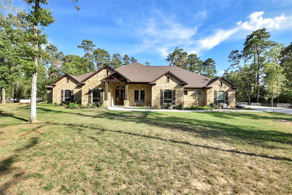 GORGEOUS custom 5 bedroom, 5.5 bath gated home sits on a little over 5 ACRES just outside The Woodlands! This home is sure to impress featuring soaring ceilings, crown molding, wood-look tile flooring & optimal guest quarters with its own living space, full bath & exterior entrance! The stunning kitchen is a chef's dream boasting an island, breakfast bar, granite counters, gas cooktop, double ovens & an abundance of cabinet space which easily flows into the light and bright living area. The premium private suite features a walk-in shower, dual vanities & huge walk-in closet. The perfect retreat awaits in your very own backyard oasis complete with a sparkling 51,000 gallon pool, covered patio, fire pit, spectacular views and plenty of room to roam! A rare beauty you don't want to miss! Must see to believe!