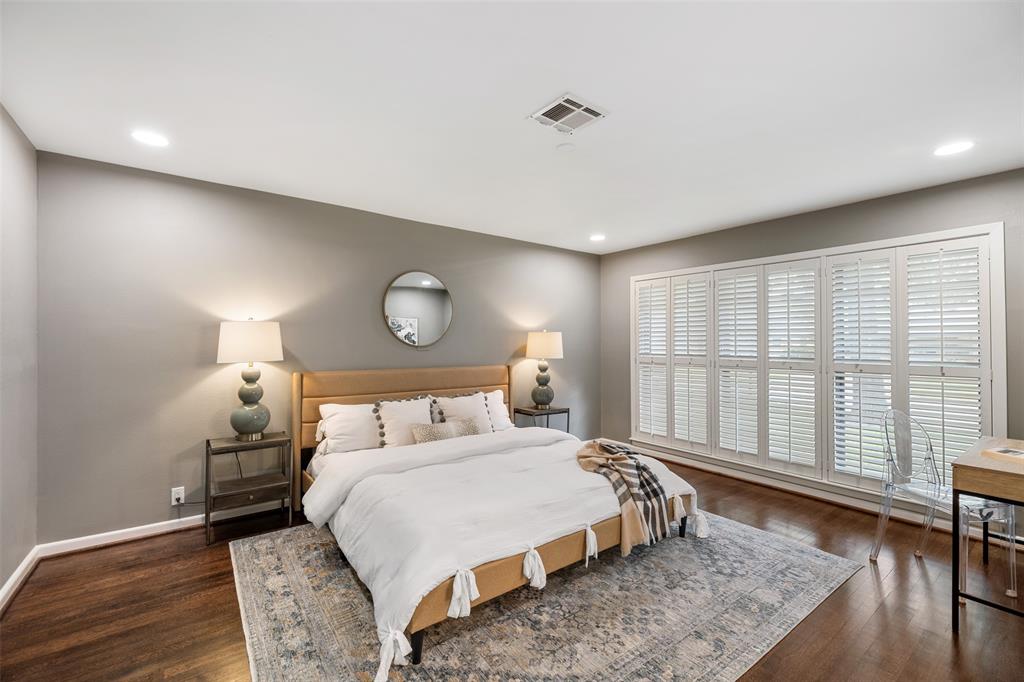 The primary suite features wood floors, recessed lights and plantation shutters.