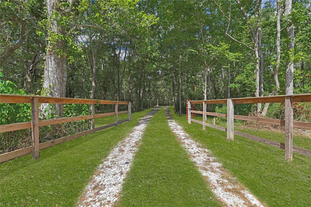 25.98 Acres wooded land appx 1650' of highway frontage 1800' Rear of property. Small cabin located in the center of clearing with front porch 12 x 32 overlooking 2 over 200-yr-old live oaks. Property surrounded with hardwoods including Oak & Pecan. No restrictions/ horses, farm animals & hunting allowed. Cabin 1 bedroom, 1.5 bath full kitchen 2-yr-old appliances 2 window units cool & heat, full-sized hot water tank. City water, Electric and Aerobic septic system. Cabin can sleep up to 7. 16x18 Metal car cover, 16x24 storage shed & 12 x12 storage building. 2 Deer Blinds & 4 feeders convey with property. 2 ponds E Pond appx 40x30 8' deep & has bass, W Pond appx 50x100 7' deep stocked catfish, bass & minnows. Land has deer, hogs, squirrels & more. Large Skid Steer available for purchase info in Agent details. Do not miss this chance to own your personal Retreat.
