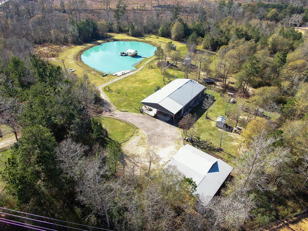 Lots of possibilities for this beautiful 16.4 acres located off of FM 1097 in Willis,Tx. Property is unrestricted and can be used for commercial or residential use. There is a 3/4 acre aerated pond stocked with bass and catfish, along with relaxing beach access and floating covered dock. There is an additional 25x30 metal building that was built in 2018. The main home is a Barndominium style build with a climate controlled indoor/outdoor area with an outdoor kitchen, full bathroom, and plenty of room for activities. The interior of the home includes three bedrooms and two full bathrooms, spacious living room and dining room, as well as an office. The kitchen has stainless steel appliances, farm house sink and granite countertops. The primary bedroom has a large walk in closet and an en suite that includes dual vanities with separate tub and shower. The home is also equipped with both a whole-home generator and water softener.