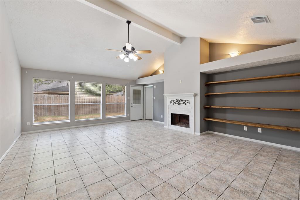 Very spacious living room with vaulted ceilings, a gas fireplace and rustic built in shelves