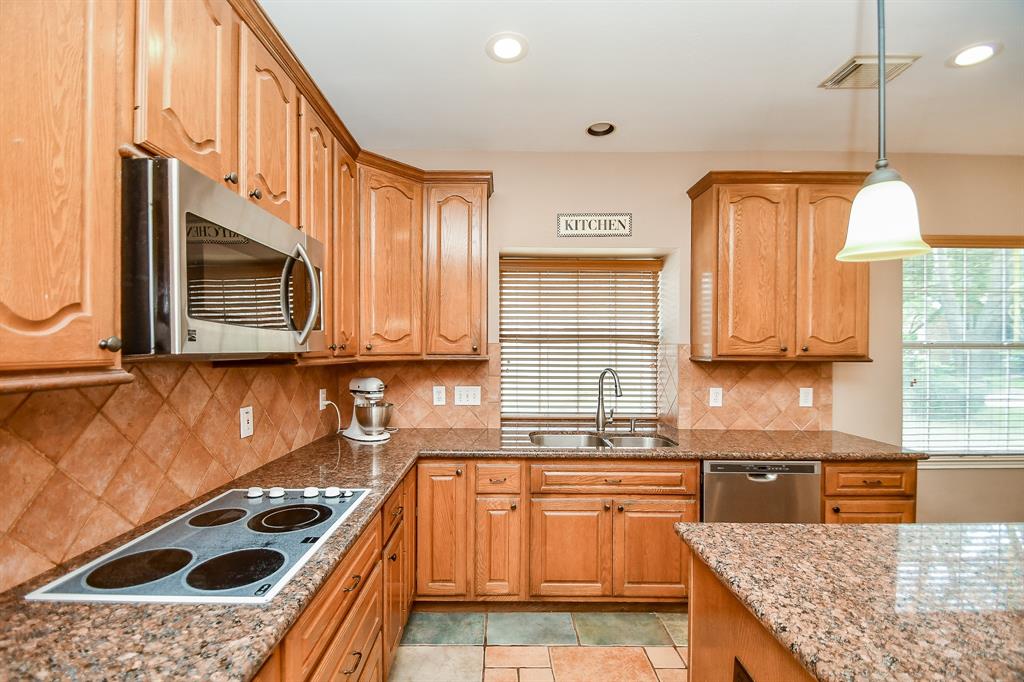 Every task is easy in this chef's dream kitchen; with beautiful tile flooring, creamy granite counter tops, adobe colored tile backsplash, honey colored cabinetry (wth lots of storage space), flat top cooktop, a window over the dual stainless sinks and easy navigating space, galore!