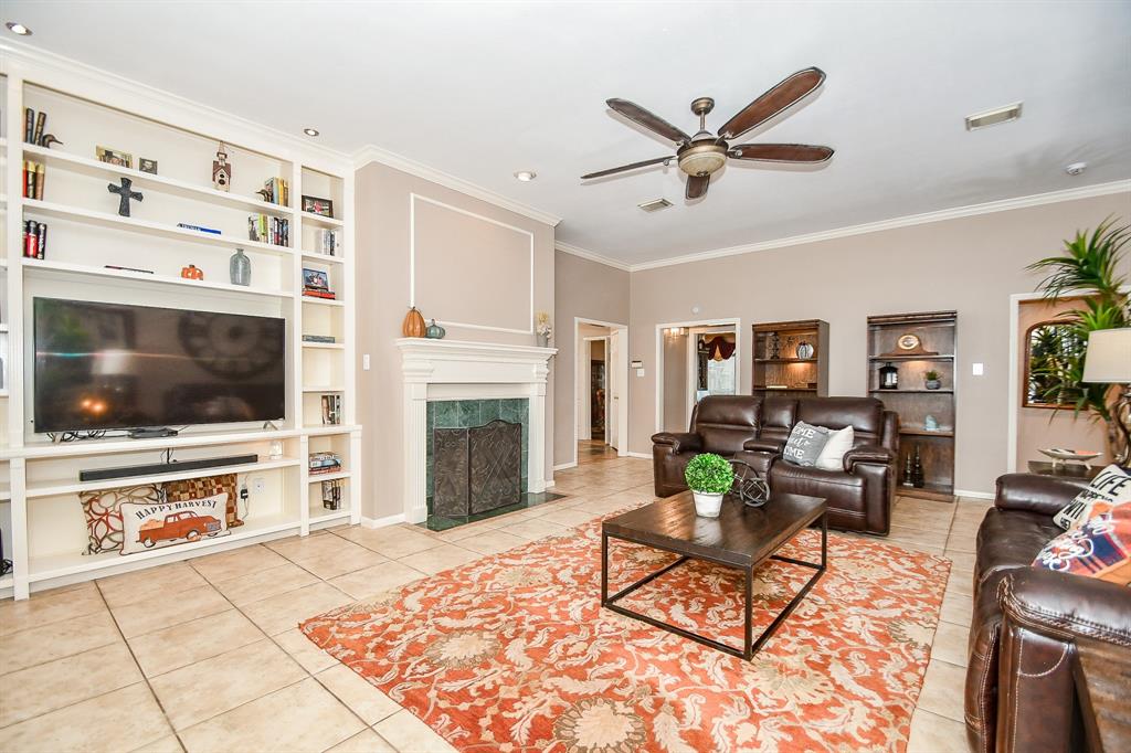 This enormous space is your gorgeous living/family area! Big, square earth-toned tiles fill the floor, with light mocha walls and white crown molding trim. Don't worry that your big, ovesized pieces won't fit. As you can see, you've got plenty of room!