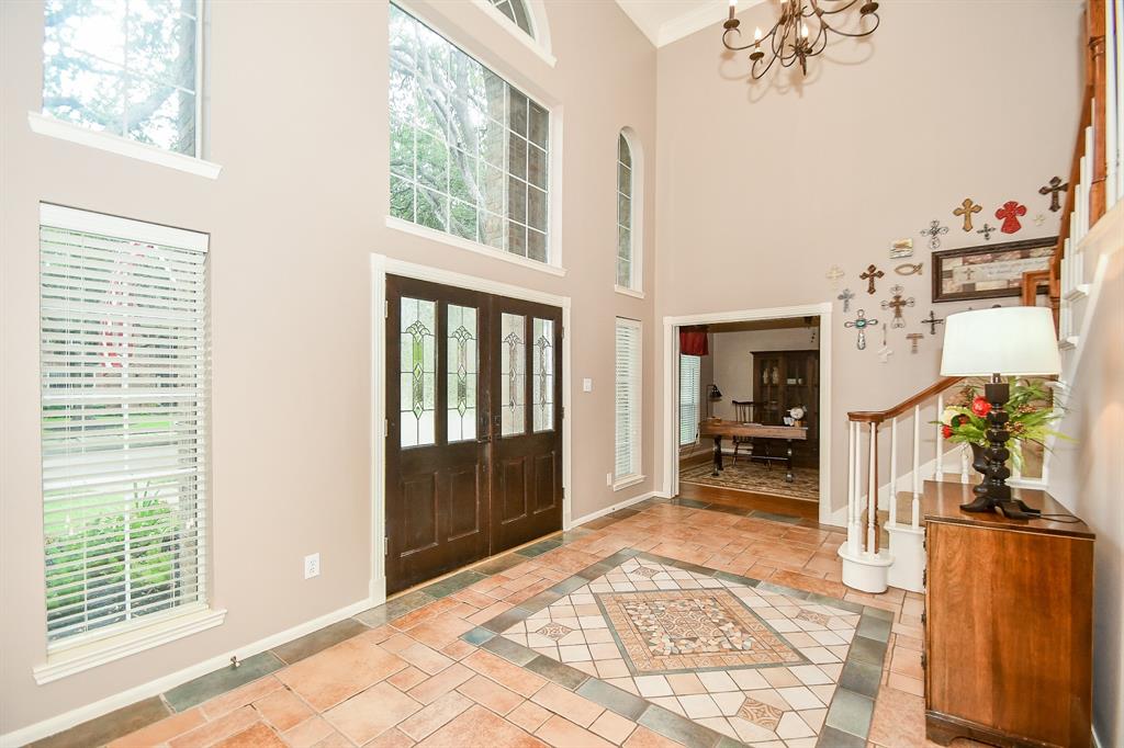 A heavenly high ceiling, earth tones on walls and exquisite custom tile flooring, greet family and friends, in this view of your main entry from the inside. (Up right, is a divine study/home office space.)