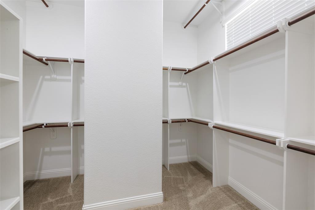 Large walk in closet with plenty of space and railings.
